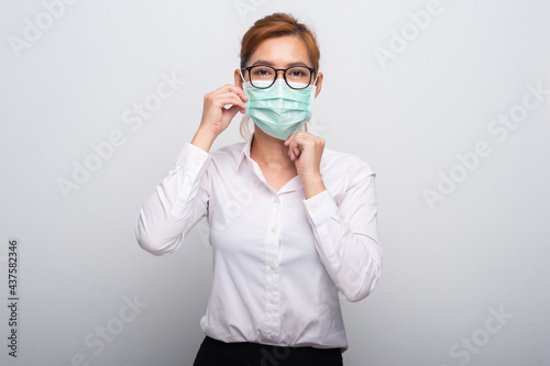 Portrait of Asian teenager in medical face mask to protect Covid-19 (Coronavirus) Casual Asian Casual Asian woman wearing white shirt over white background.