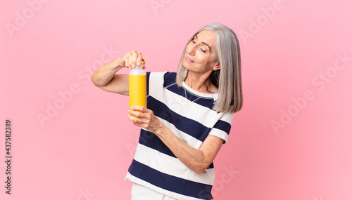 middle age white hair woman holding a coffee thermos photo