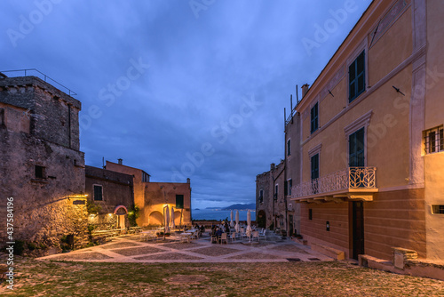 Borgio Verezzi, Italy. May 22th, 2021. Piazza Sant'Agostino at night with people sitting outdoors at a restaurant table. In the distance the view on the Ligurian Riviera in the background.