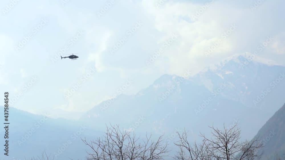 Helicopter flying in front of the snow covered mountains at Manali in Himachal Pradesh, India Helicopter flying in front of the snow covered mountains at Manali in Himachal Pradesh, India