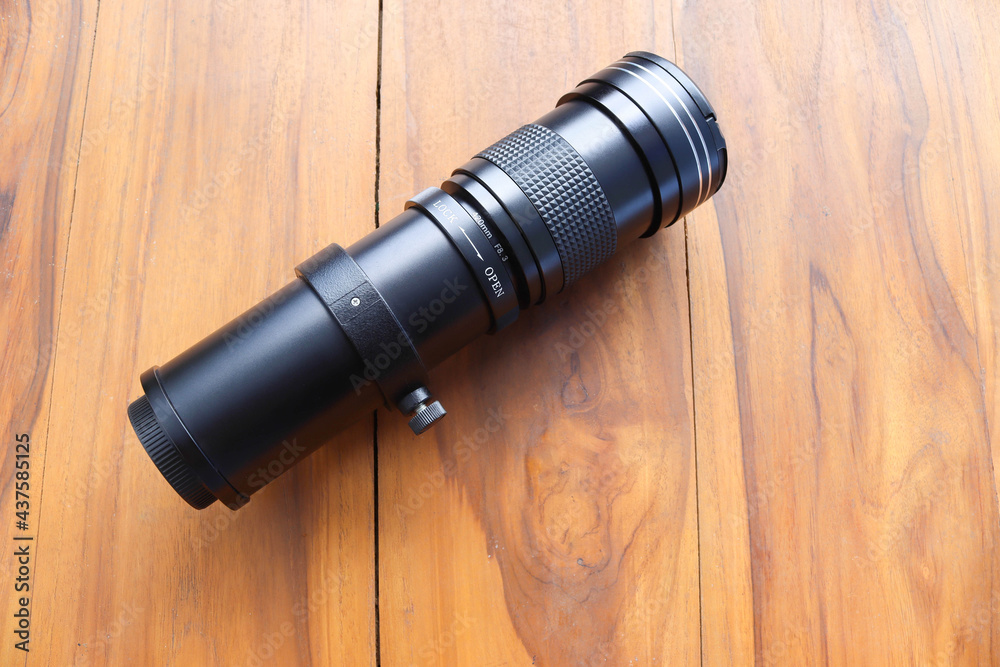 Super telephoto lens zoom, normal range isolated on wooden background closeup. Super telephoto lens zoom, normal range isolated on wooden background closeup.