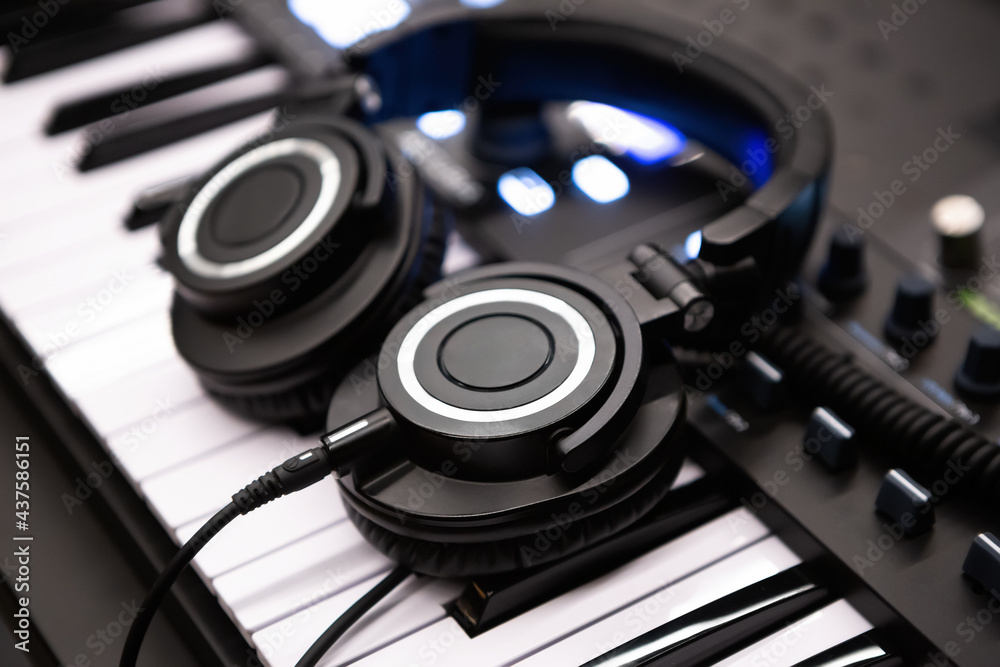 Headphones on synthesizer piano keyboard. Professional audio equipment in sound recording studio Headphones on synthesizer piano keyboard. Professional audio equipment in sound recording studio