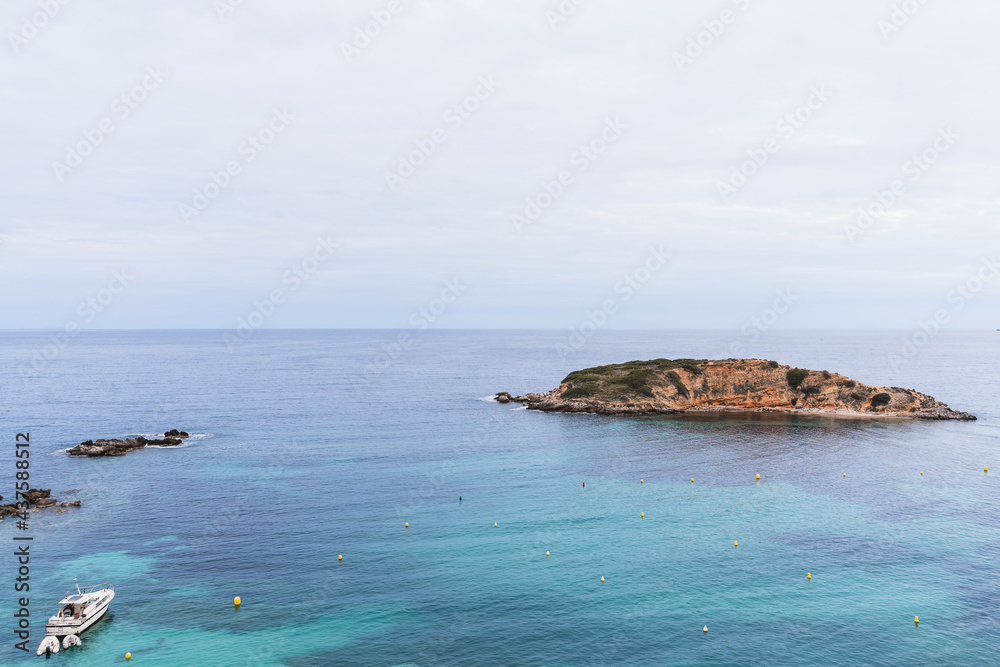 Sunset on the beach of Puerto Portals with an island in front in Palma de Mallorca, Spain