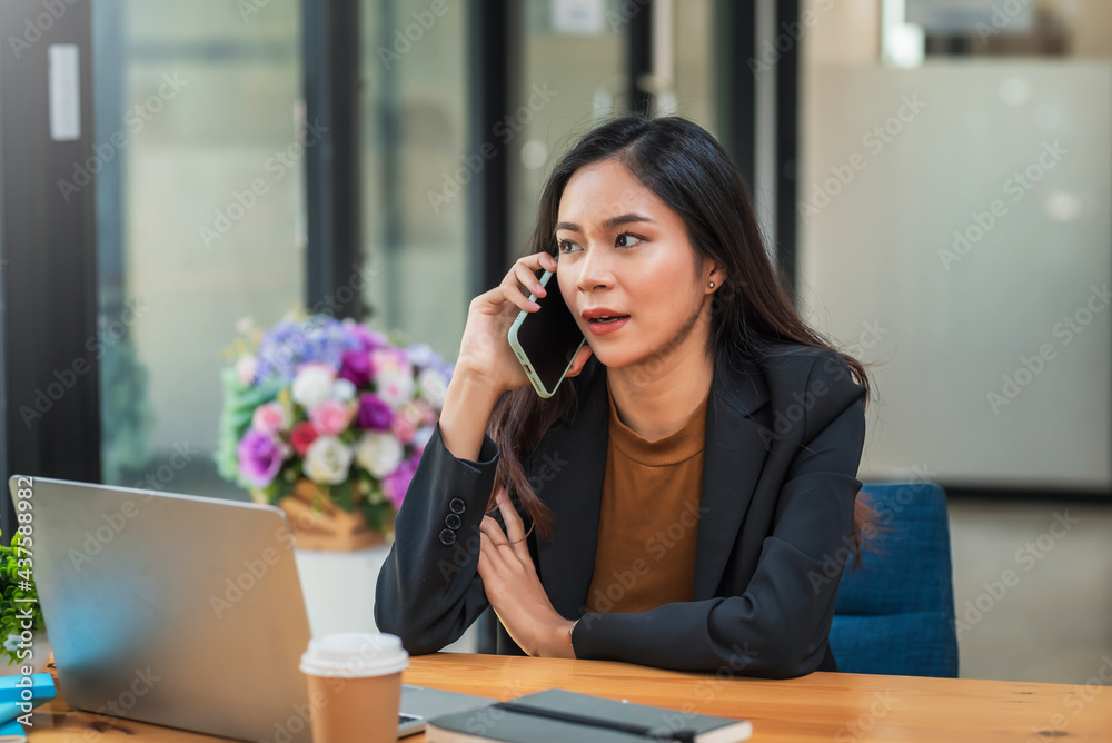 Young Asian businesswoman is working on the phone communicating with customer at the office. Young Asian businesswoman is working on the phone communicating with customer at the office.