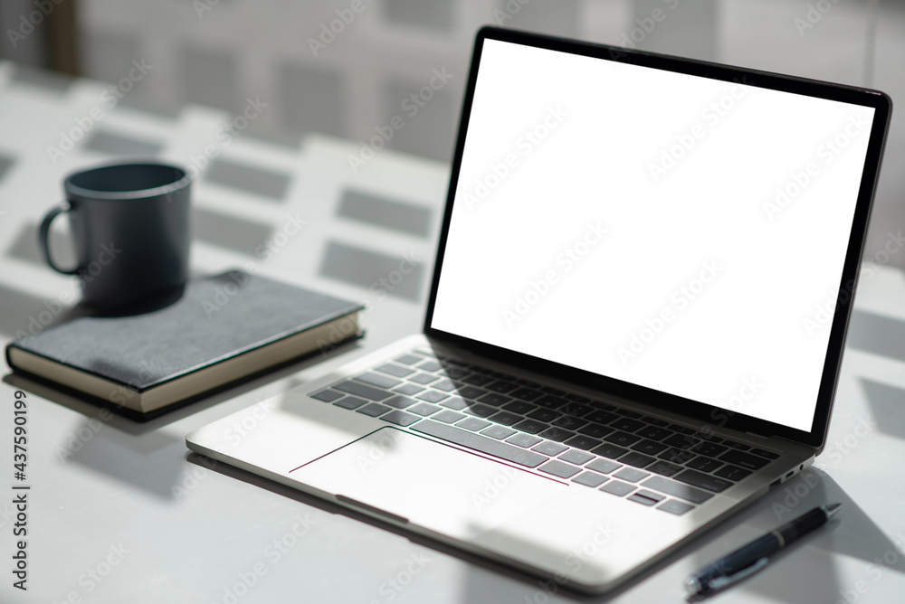 Office desk with laptop blank white screen with notebook coffee mugs. Mock up. Office desk with laptop blank white screen with notebook coffee mugs. Mock up.