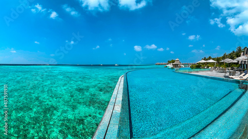 Fototapeta Naklejka Na Ścianę i Meble -  Amazing wide panorama of tropical Maldives island on a sunny day. Exotic vivid beach background with blue turquoise lagoon and palm trees. Luxurious holiday and romantic honeymoon destination.