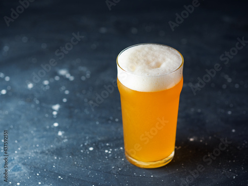 Photo New England IPA a glass of craft beer on a dark stone table with copy space