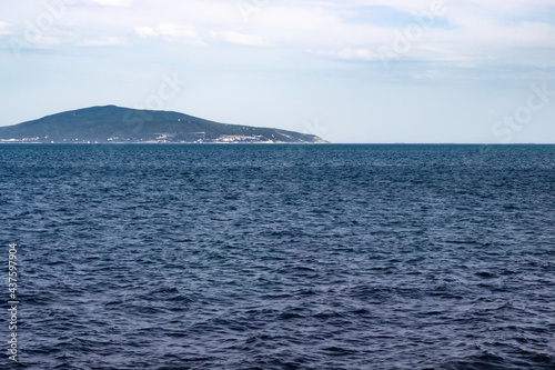 Waves on the sea surface on a background of mountains standing on the exit of the sea bay