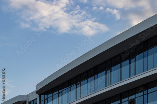 Part of a modern glass building on a background of blue sky.