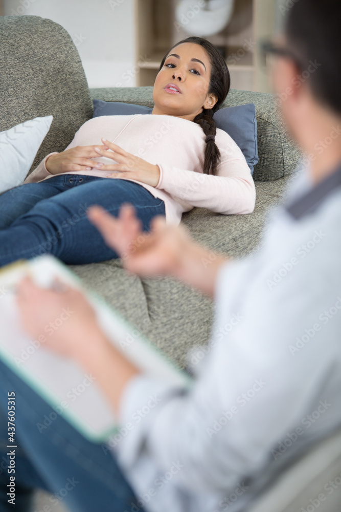 Obraz premium emotional sad woman sitting on the sofa and using gestures