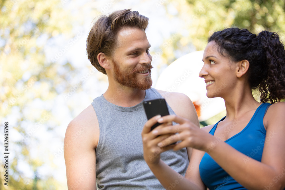 two runners checking achievements on mobile phone app two runners checking achievements on mobile phone app