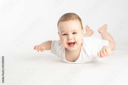 portrait of a smiling baby lying on his stomach
