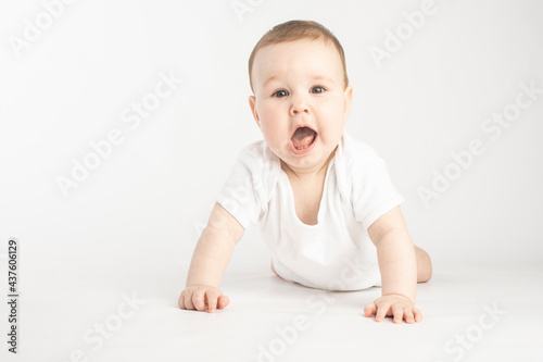 surprised baby standing in her arms on a white background.