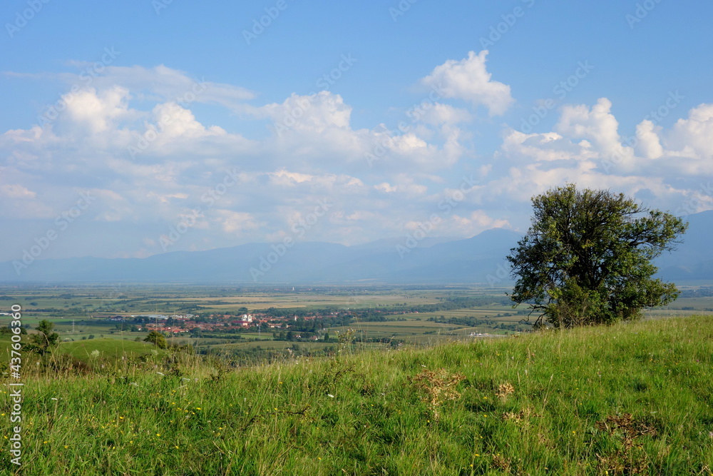 Countryside landscape in Tara Fagarasului depression in Transylvania, Romania viewed from a hill, with villages, fields and mountains and white clouds on blue sky
Countryside landscape in Tara Fagarasului depression in Transylvania, Romania viewed from a hill, with villages, fields and mountains and white clouds on blue sky