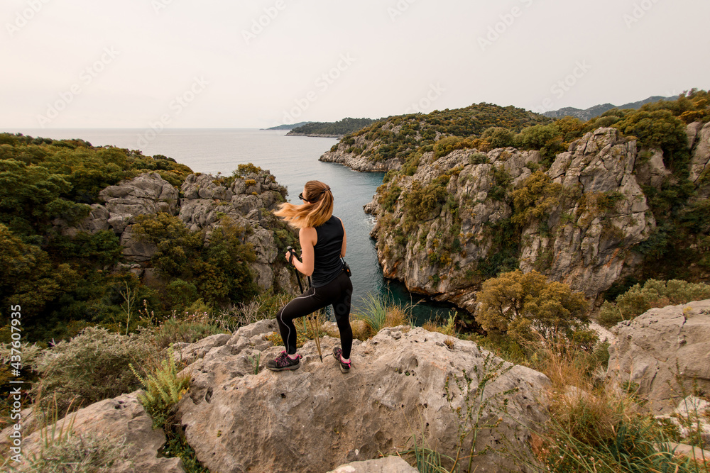 Rear view of attractive woman against beautiful landscape and seascape of Mediterranean Sea nature