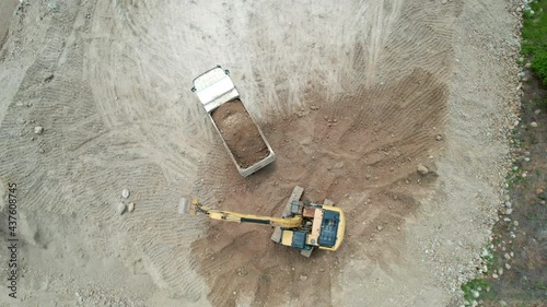 Loading gravel into a truck with a bulldozer. Extraction of gravel. Aerial view