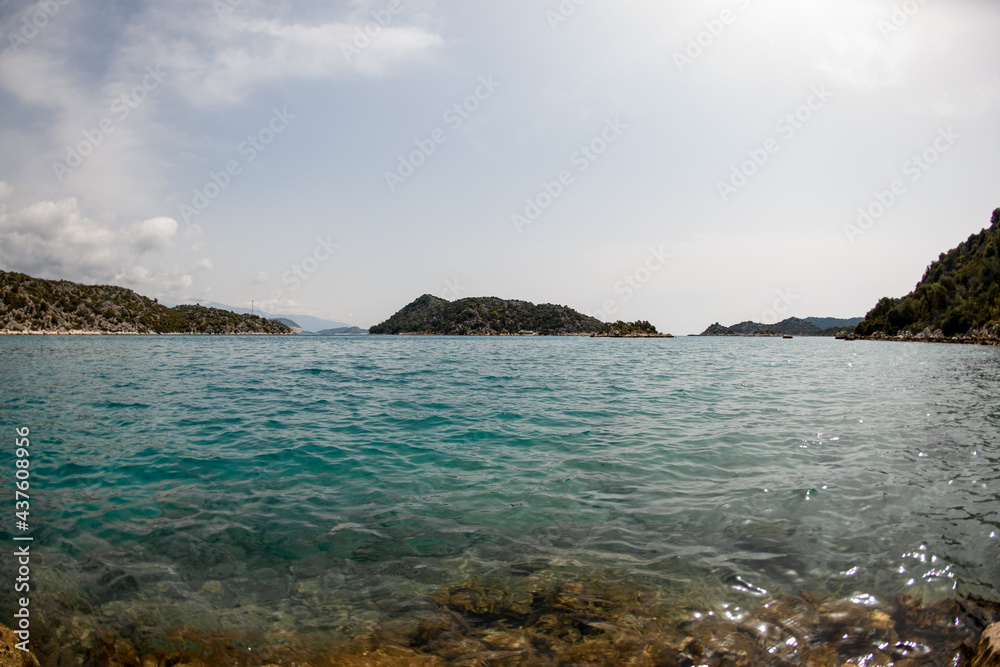 Great view of sky and turquoise sea surface and mountains at horizon