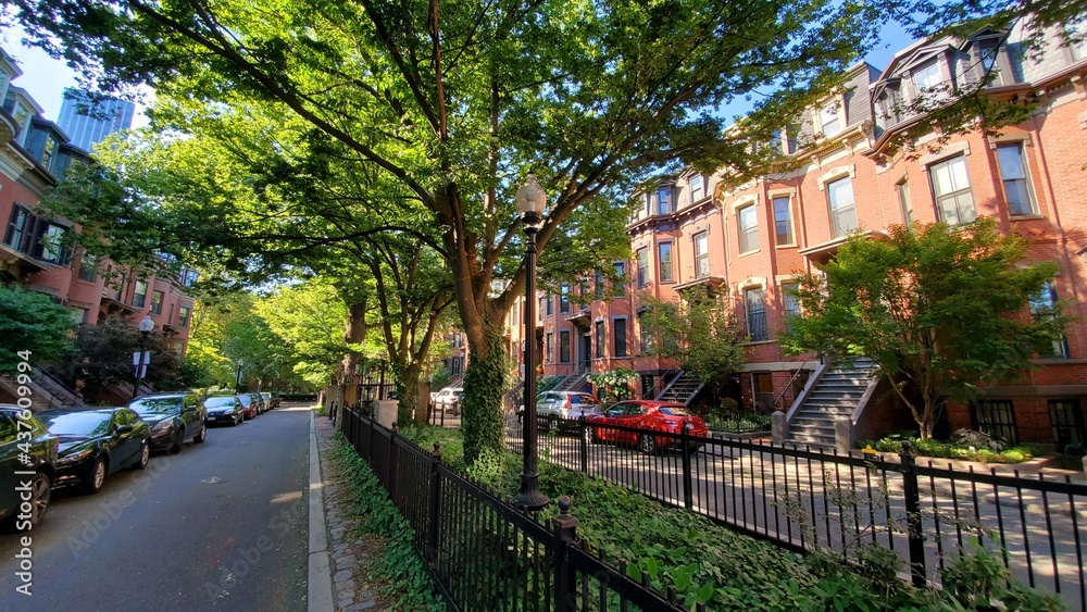 green street in the city with red buildings and trees