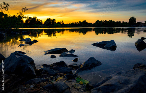 Sonnenuntergang am See mit Steinen im Vordergrund