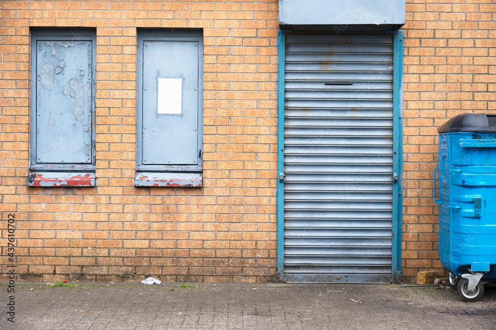 Shop front with blank sign and closed shutter door