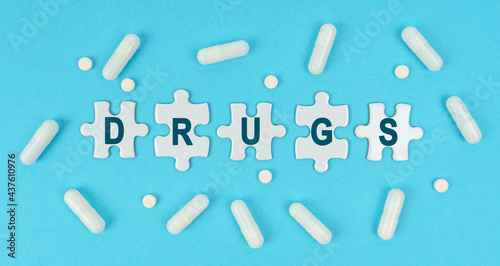 On a blue background, there are pills and puzzles with the inscription - DRUGS