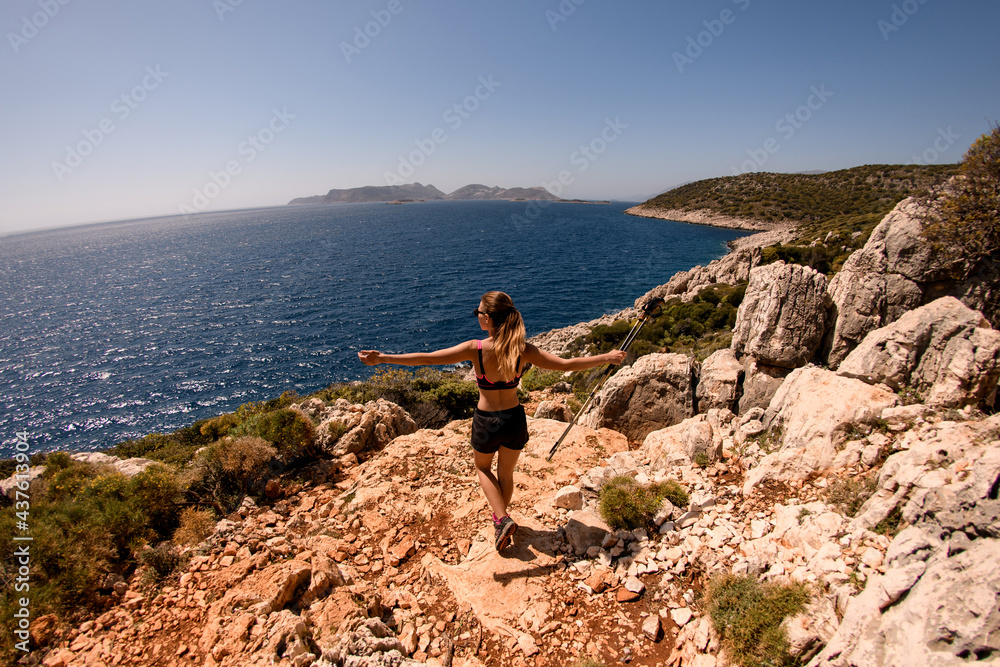 rear view of woman spreading her arms wide to the sides on seascape background. rear view of woman spreading her arms wide to the sides on seascape background.