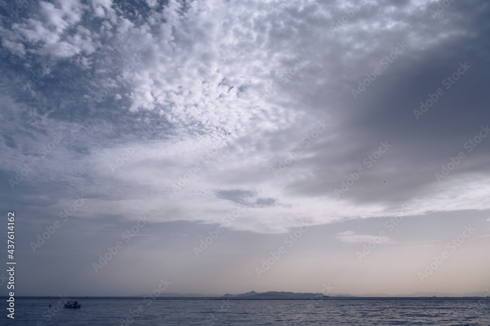 Obraz premium Beautiful landscape of Aegean sea in Athens at cloudy day. Lonely boat. Silhouettes of islands in the mist. Nobody. Greece.