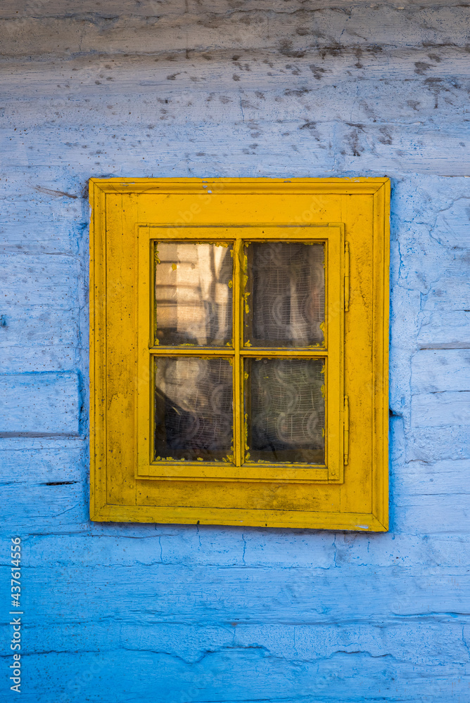 Vlkolinec, Slovakia, yellow window with ob wooden blue old wall. 