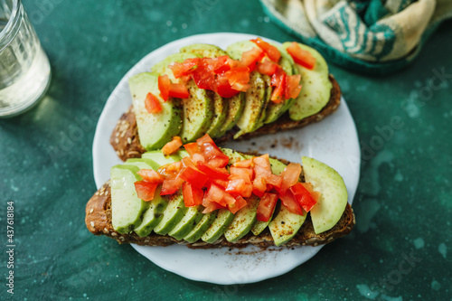 Fototapeta Naklejka Na Ścianę i Meble -  Tasty fresh toast with avocado and tomatoes