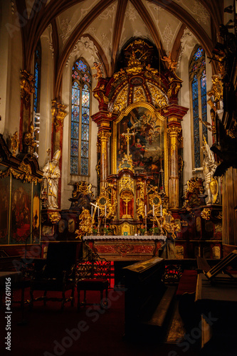 Decorative interior of church St. Henry and St. Kunhuty  gilded ornamented baroque main altar  gothic stained glass windows  marble statues  wood carved benches  Prague  Czech Republic
