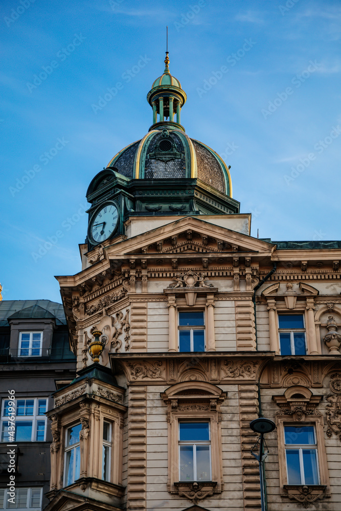 Neo-renaissance style Stybl's house at Wenceslas Square, green copper dome with clock and small turret, CSOB bank building in sunny day, stone stucco, blue sky, Prague, Czech Republic