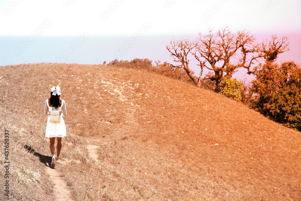 Young pretty Asian woman walking on the hill.