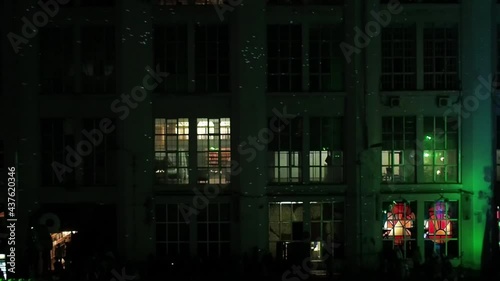 The light from the disco ball moves along the facade of the building at night