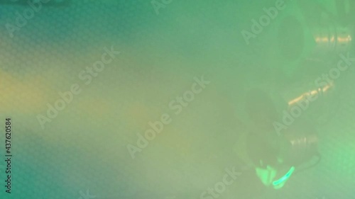 Three classic stage spotlights flash in the green fog under the stage ceiling