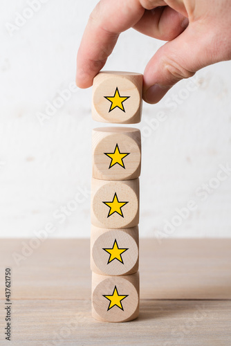 hand stacking cubes with star symbols on wooden background photo