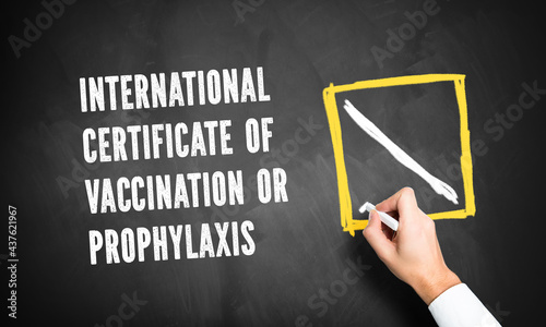 hand checking a checkbox besides the message INTERNATIONAL CERTIFICATE OF VACCINATION OR PROPHYLAXIS on a blackboard photo