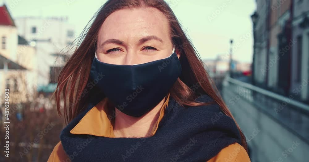 Mask as a new normal. Portrait of young happy beautiful Caucasian woman smile in sunny city street during quarantine. Mask as a new normal. Portrait of young happy beautiful Caucasian woman smile in sunny city street during quarantine.