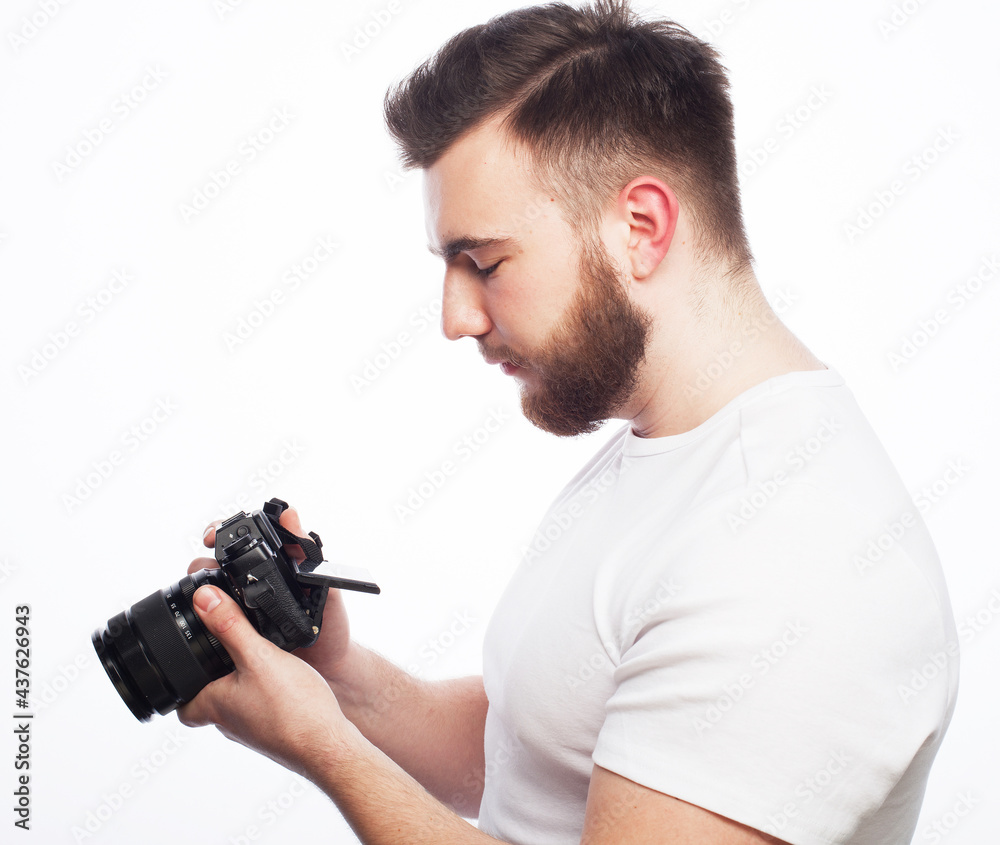 Young bearded photographer looking at photos on the camera screen Young bearded photographer looking at photos on the camera screen