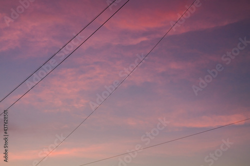 Sky during sunset with red clouds and power wires. Industry and nature.