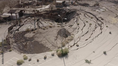 Large sinkhole close to house In the desert, Aerial view
drone view from dead sea sinkhole, Israel 2021
 photo
