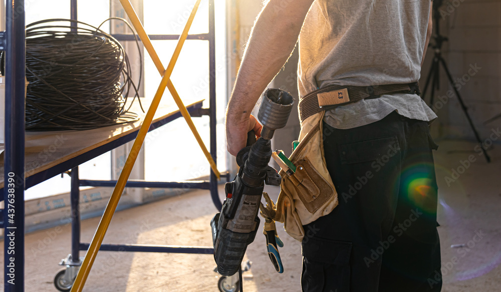 Worker at a construction site with a tool in his hand. Worker at a construction site with a tool in his hand.