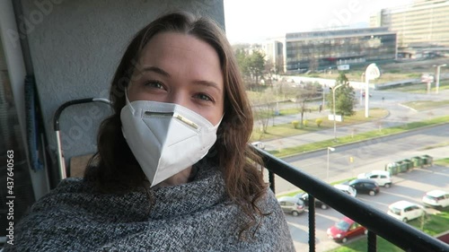 Pretty young woman vlogging on the street wearing a white face mask