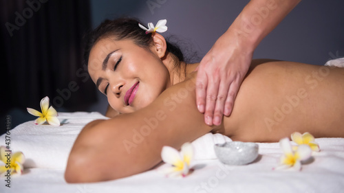 Thai oil massage to smiling woman in spa