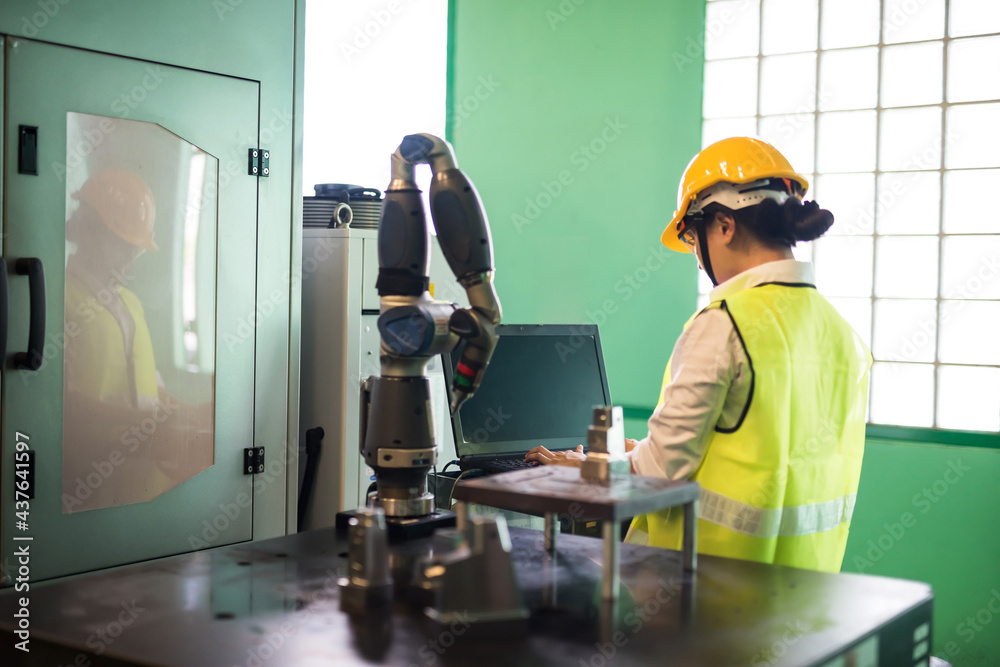 Factory worker control lache robot arm by computer