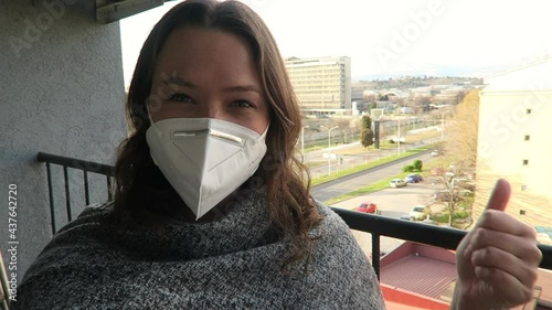 Young beautiful woman recording vlog outside wearing a face mask