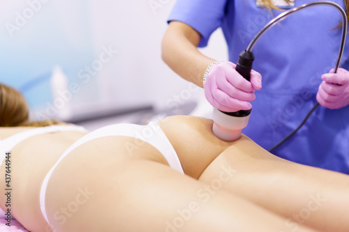 Woman receiving anti-cellulite treatment with radiofrequency machine in a beauty center.
