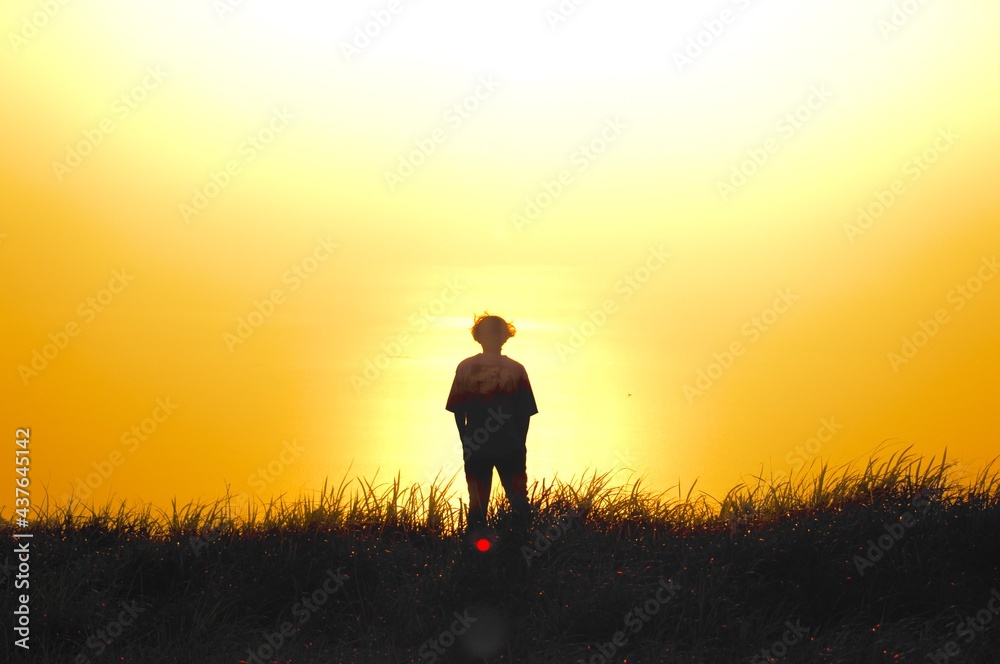 silhouette of a person walking on a meadow