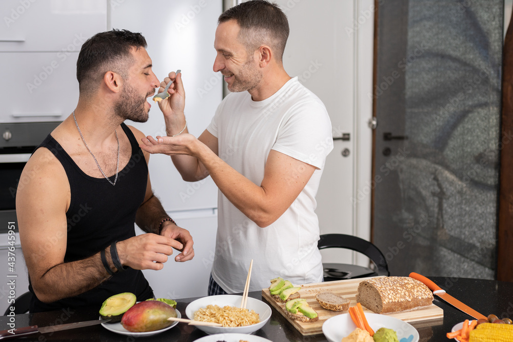 Gay couple cooking healthy vegan food together at home. Gay couple cooking healthy vegan food together at home.