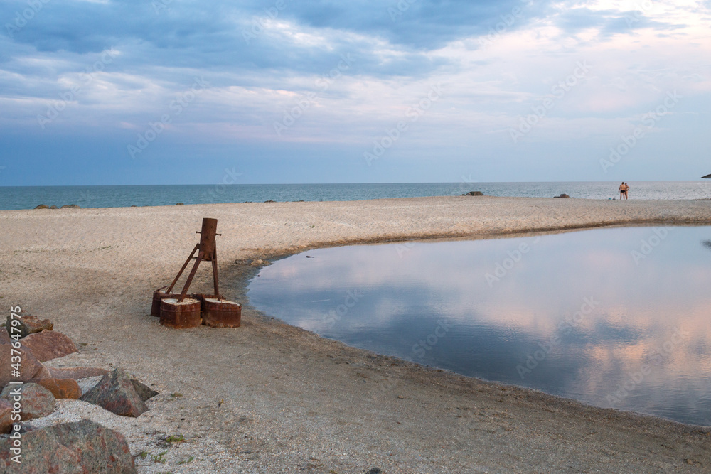A sparsely populated beach with straw umbrellas at the end of the swimming season on the south coast. A sparsely populated beach with straw umbrellas at the end of the swimming season on the south coast.