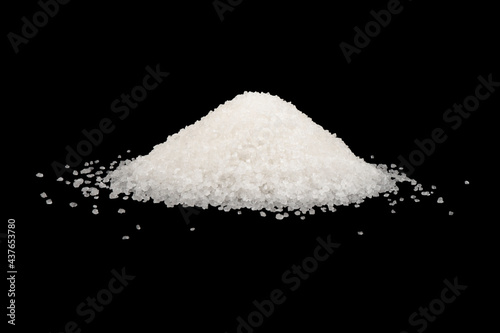 Heap of white sugar isolated on a black background. A pile of powdered white granulated sugar isolated.